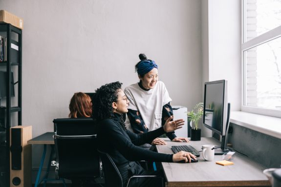 Japanese woman helping her colleague at the office.